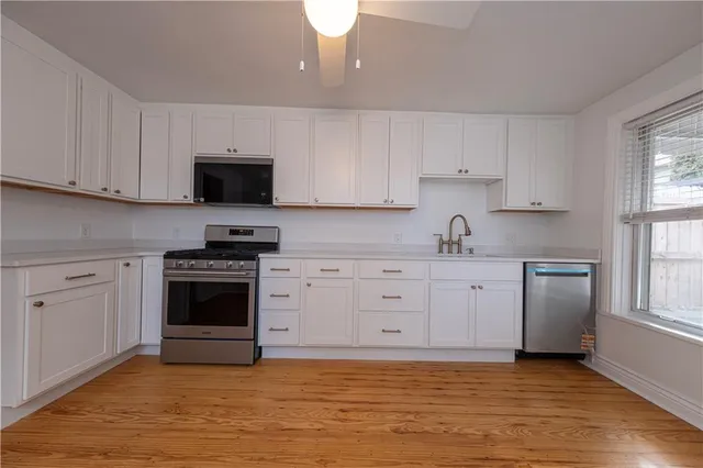 a kitchen with granite countertop a stove a sink and a microwave