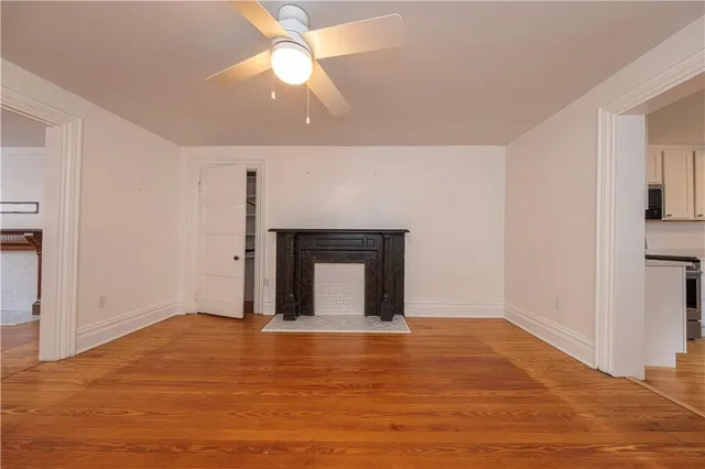 a kitchen with stainless steel appliances granite countertop a refrigerator a stove a microwave oven cabinets and wooden floor