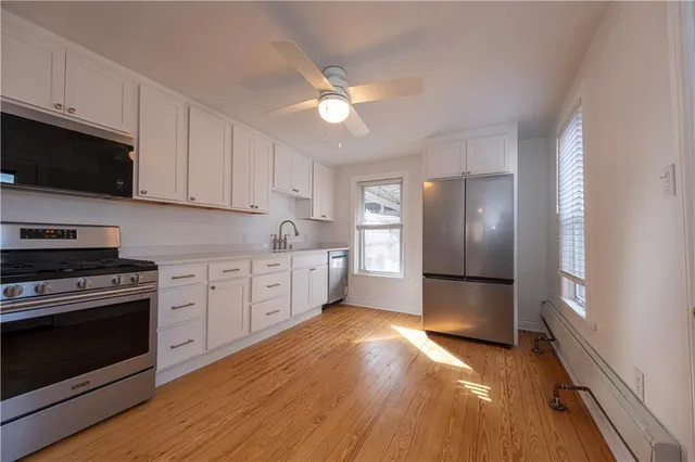 a kitchen with granite countertop a stove cabinets and wooden floor