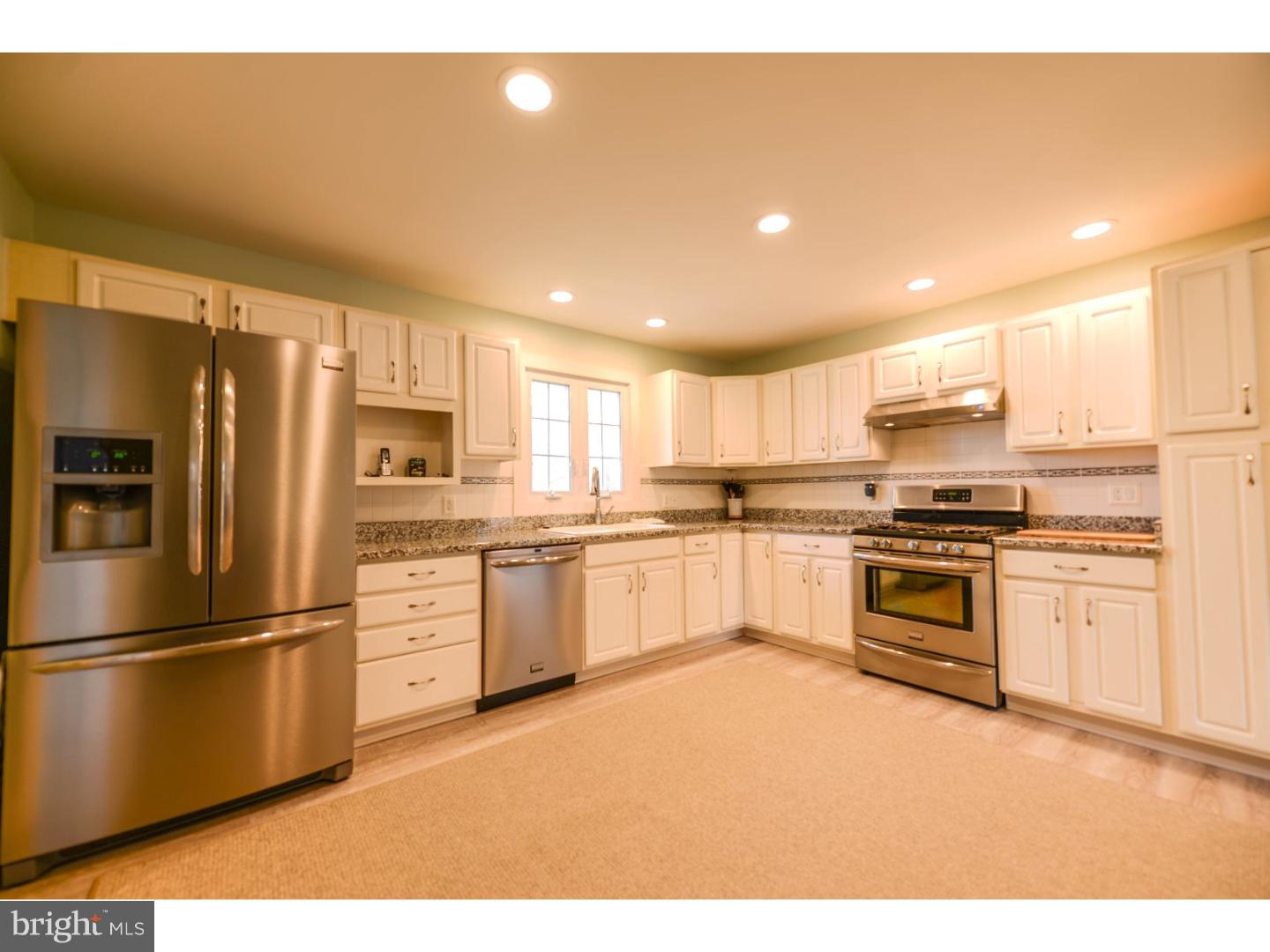 72 Kansas Road Pennsville, NJ 08070 - Photo 2 of 22 a kitchen with granite countertop a refrigerator oven a sink and white cabinets