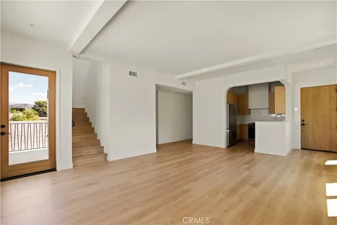a view of empty room with wooden floor and fireplace