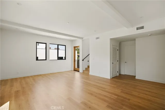 a view of empty room with wooden floor and windows