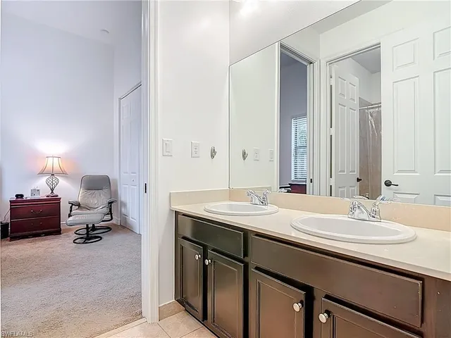 a en suite bathroom with a double vanity sink and a mirror