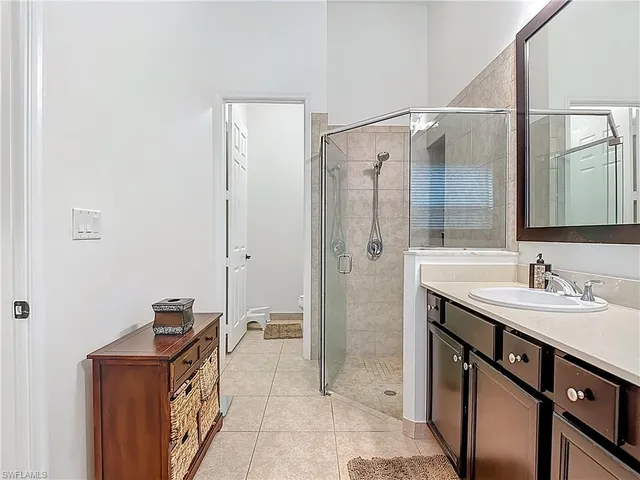 a bathroom with a sink mirror and shower