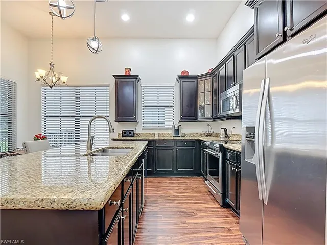 a kitchen with kitchen island granite countertop a sink stove and refrigerator