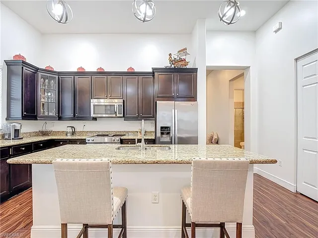 a kitchen with a sink stools a counter space and cabinets