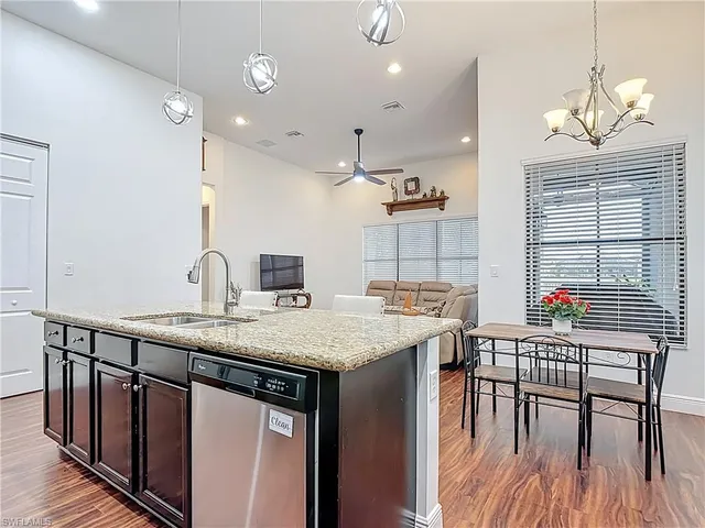 a kitchen with stainless steel appliances granite countertop a kitchen island a stove and a table