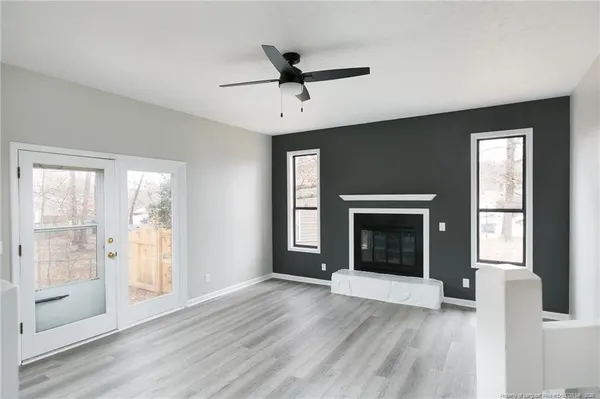 a view of an empty room with window and fire place