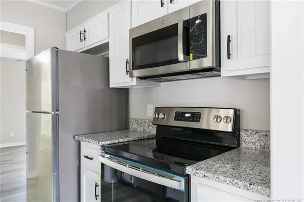 a kitchen with stainless steel appliances granite countertop a stove microwave and refrigerator
