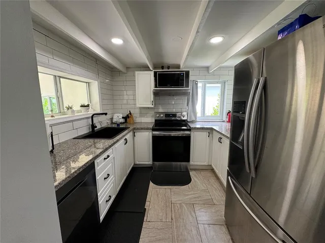 a kitchen with a sink stainless steel appliances and cabinets