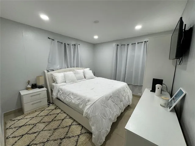 a bedroom with a bed and a flat screen tv