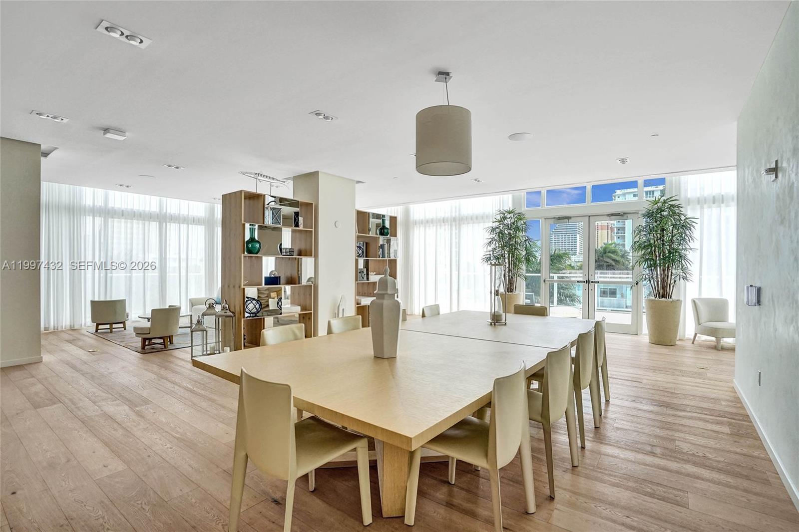 401 North Birch Road, Unit 404 Fort Lauderdale, FL 33304 - Photo 20 of 39 a dining room with wooden floor a chandelier a glass table and chairs