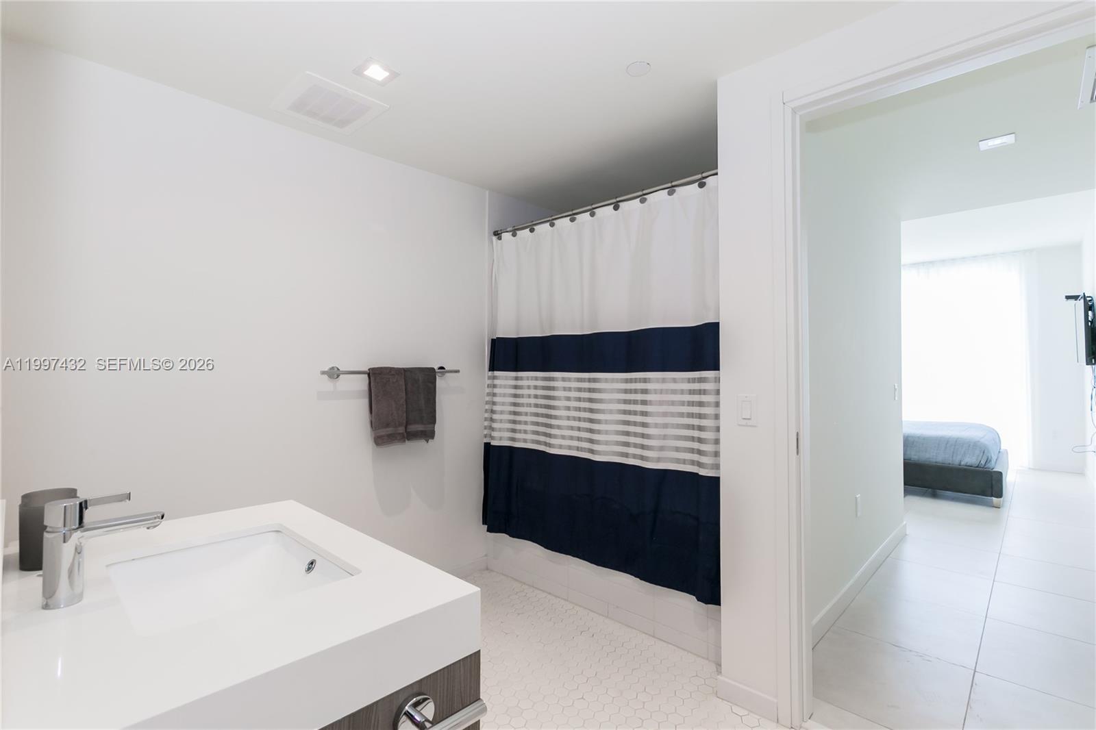 401 North Birch Road, Unit 404 Fort Lauderdale, FL 33304 - Photo 9 of 39 a bathroom with a sink and a washing machine