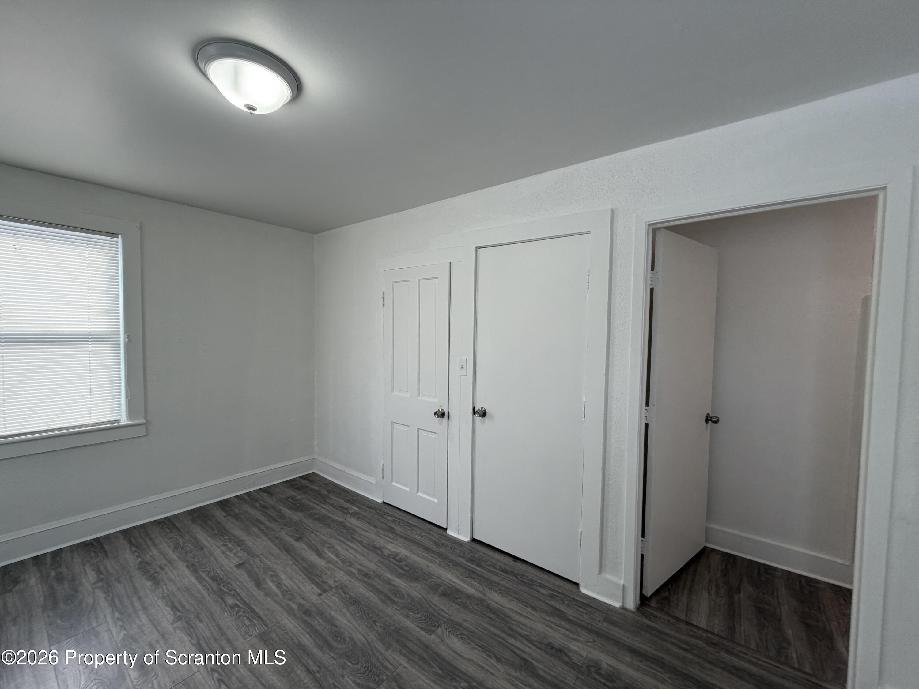 101 Clarkson Street, Unit 2 Jessup, PA 18434 - Photo 9 of 15 an empty room with wooden floor and windows