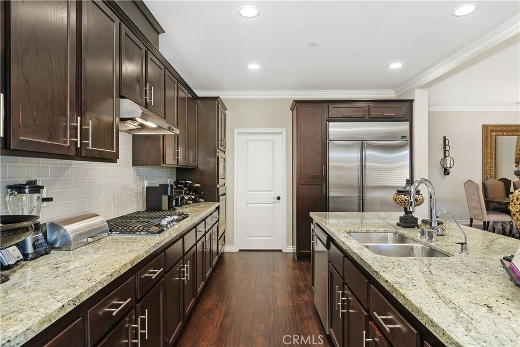 24128 Deputy Way Menifee, CA 92584 - Photo 11 of 34 a kitchen with stainless steel appliances granite countertop a sink stove cabinets and wooden floor