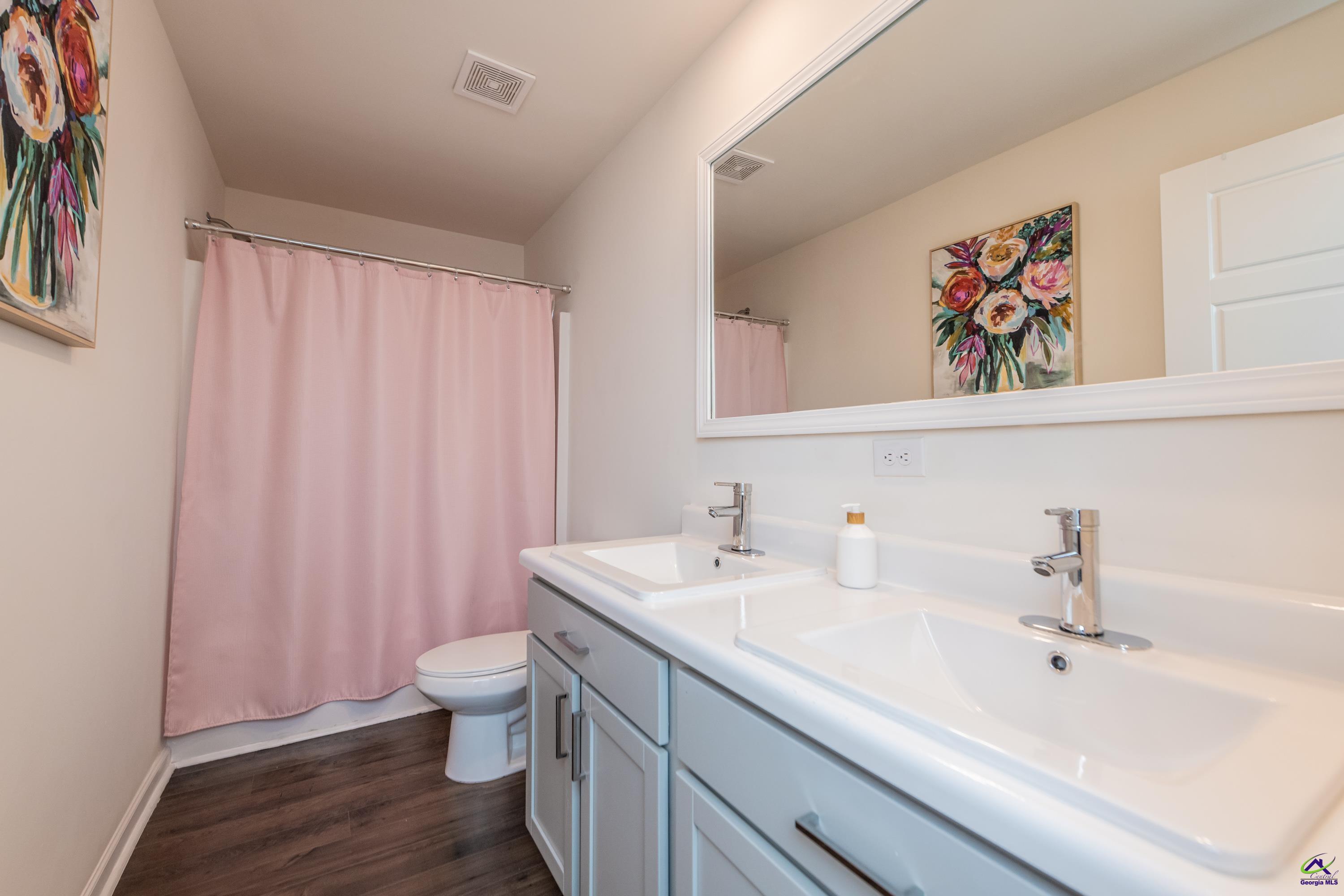 126 Farmers Way Perry, GA 31069 - Photo 27 of 39 a bathroom with a sink a toilet and shower curtain