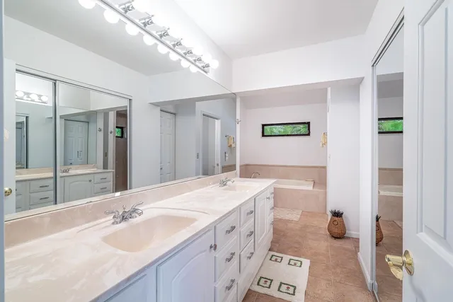 a spacious bathroom with a double vanity sink mirror and double