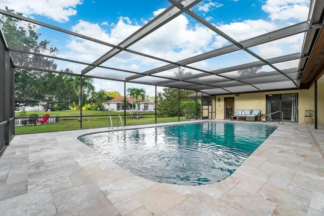 a view of a backyard with table and chairs under an umbrella