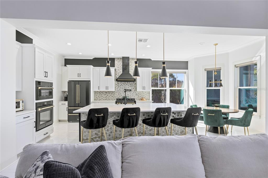 12664 Banting Terrace Orlando, FL 32827 - Photo 17 of 79 a kitchen with stainless steel appliances kitchen island granite countertop a stove and a refrigerator