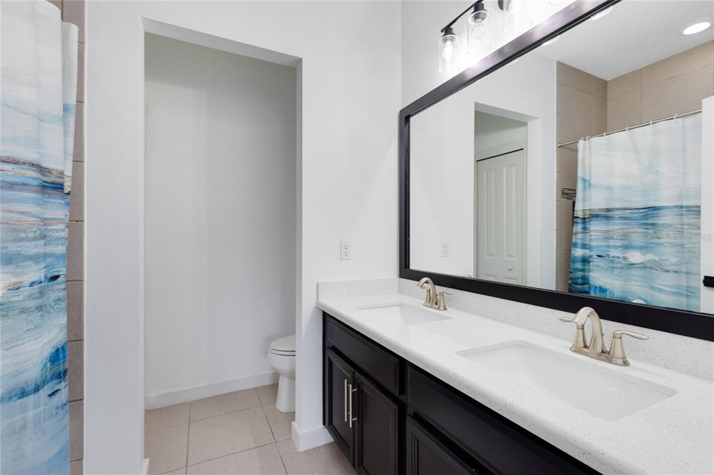 12664 Banting Terrace Orlando, FL 32827 - Photo 40 of 79 a bathroom with a double vanity sink and a mirror