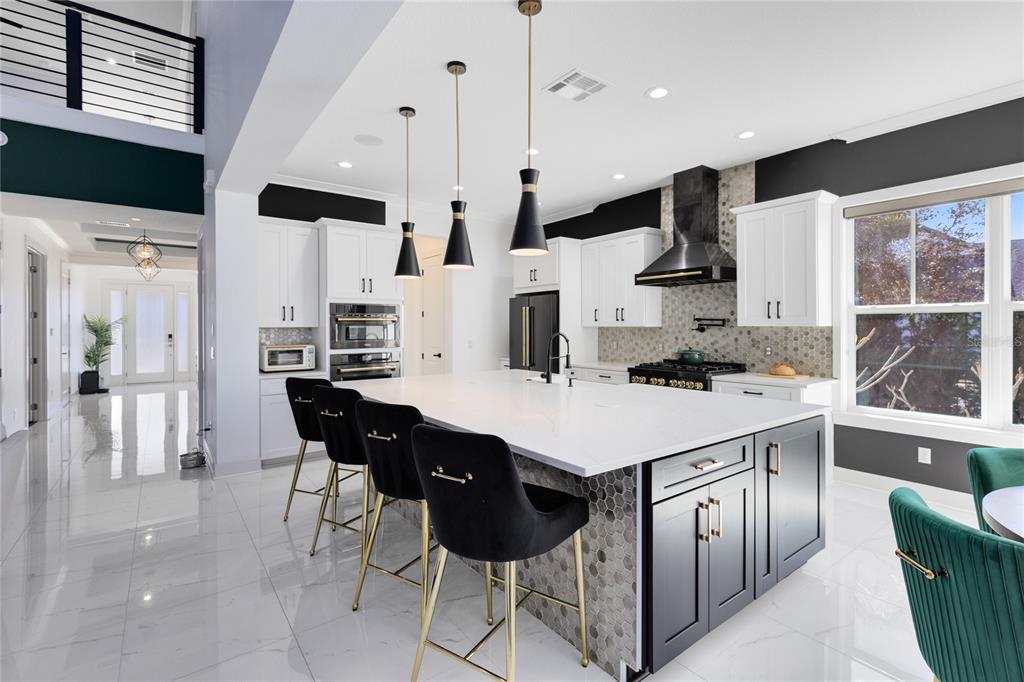 12664 Banting Terrace Orlando, FL 32827 - Photo 5 of 79 a kitchen with stainless steel appliances kitchen island a table chairs and a refrigerator