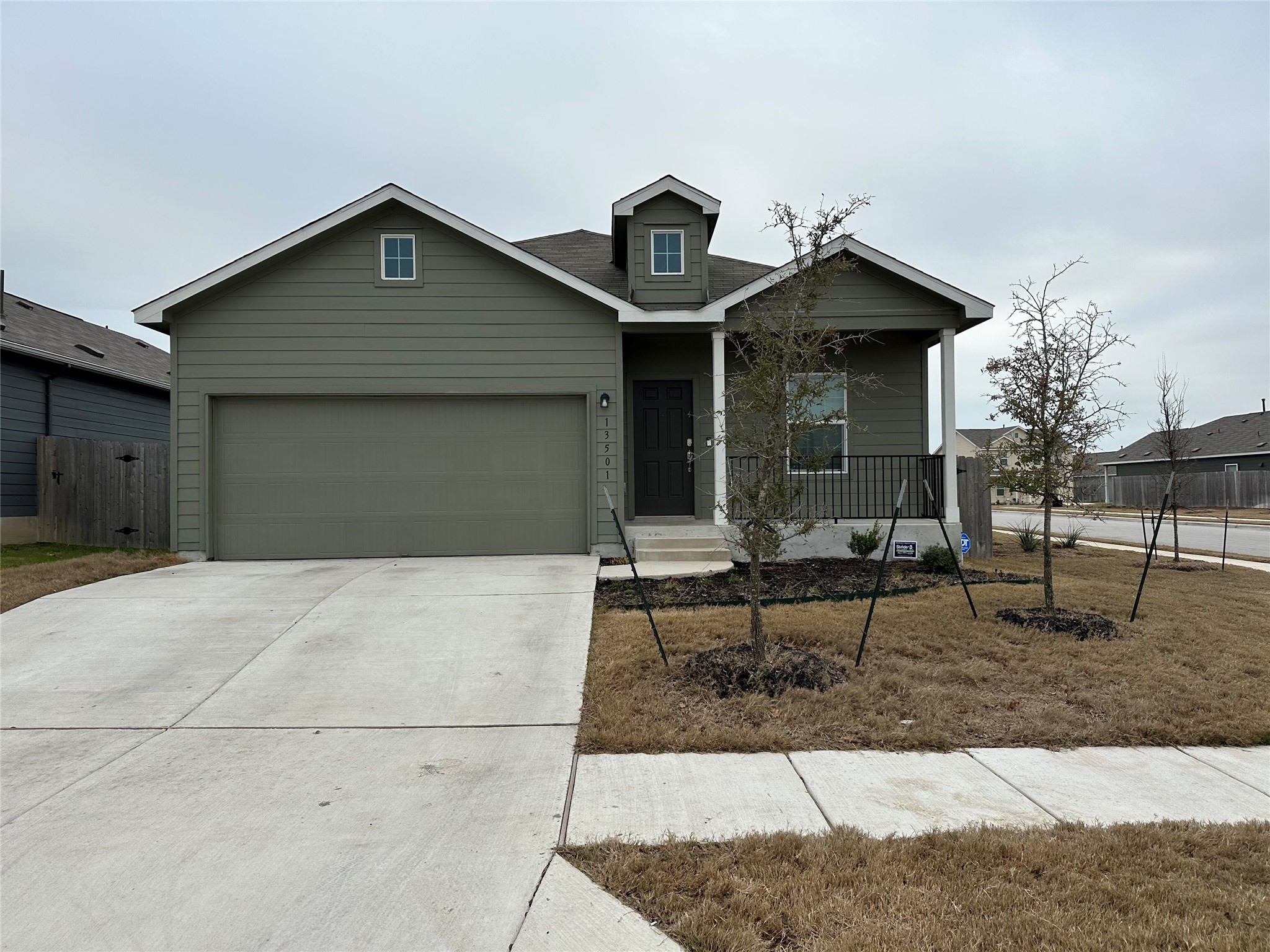 13501 Mussel Run Elgin, TX 78621 - Photo 2 of 28 Single-story residence featuring a two-car garage, covered entry porch, and a dormer window detail