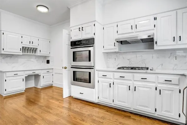 a view of kitchen with stainless steel appliances cabinets and wooden floor