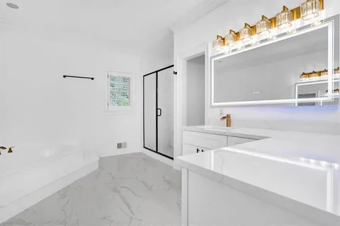 a spacious bathroom with a double vanity sink a mirror and a bathtub