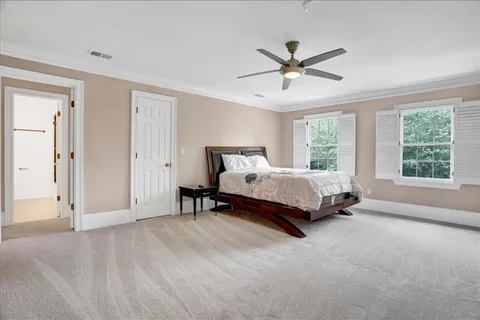 a spacious bedroom with a bed and a chandelier