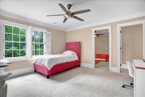 a bedroom with a bed lamp and a large window
