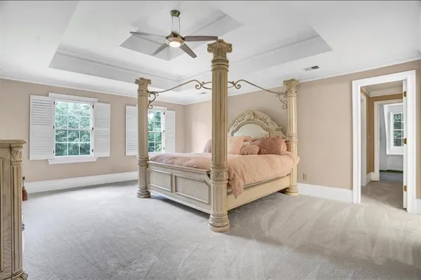 a spacious bedroom with a bed and a ceiling fan
