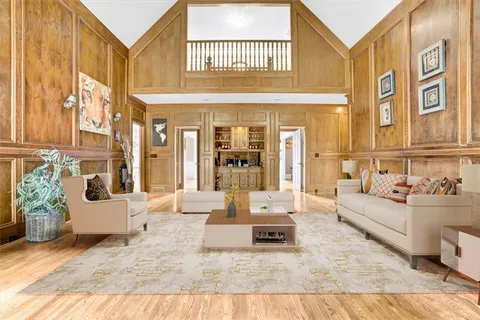 a living room with furniture fireplace and a large window