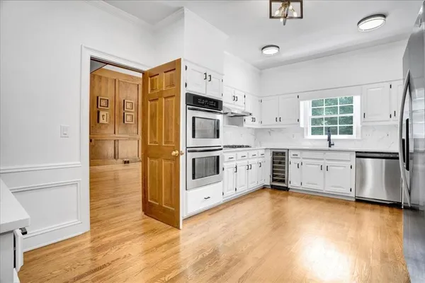 a kitchen with stainless steel appliances white cabinets and a sink