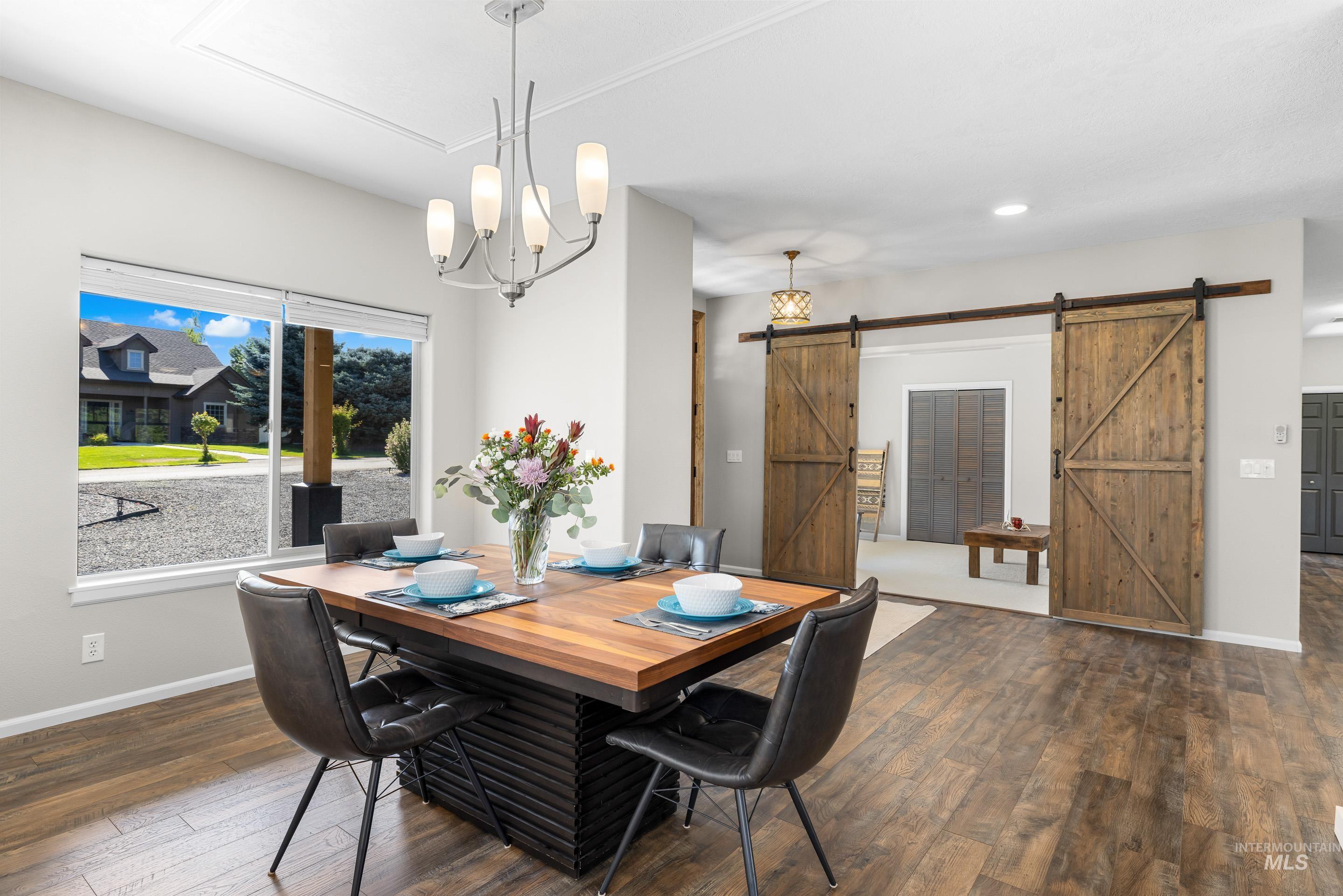 14119 Silver Ridge Road Caldwell, ID 83607 - Photo 14 of 50 Dining area featuring dark wood finished floors, a chandelier, recessed lighting, and a barn door