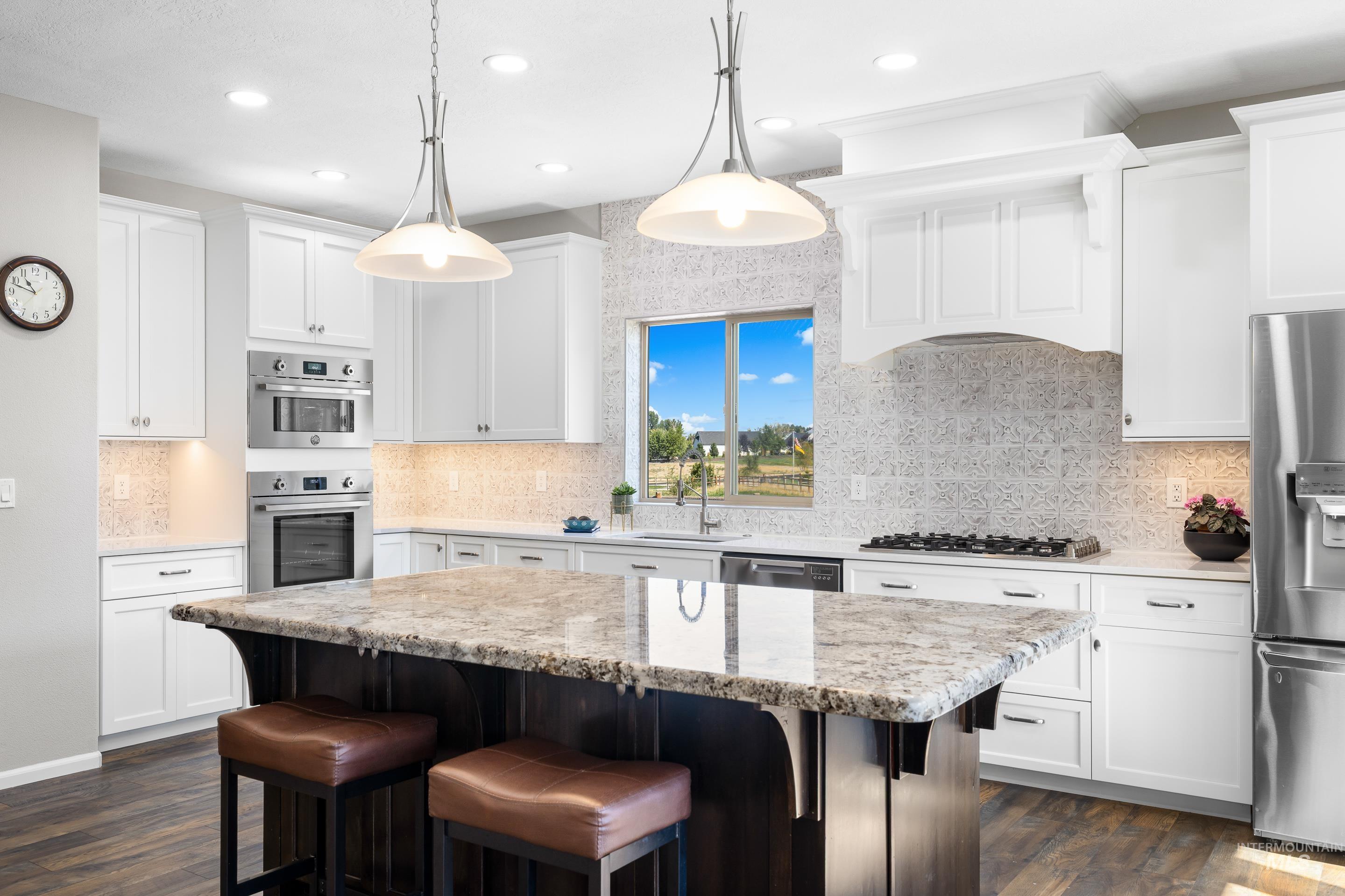 14119 Silver Ridge Road Caldwell, ID 83607 - Photo 16 of 50 Kitchen featuring backsplash, a breakfast bar, a center island, stainless steel appliances, and light stone countertops