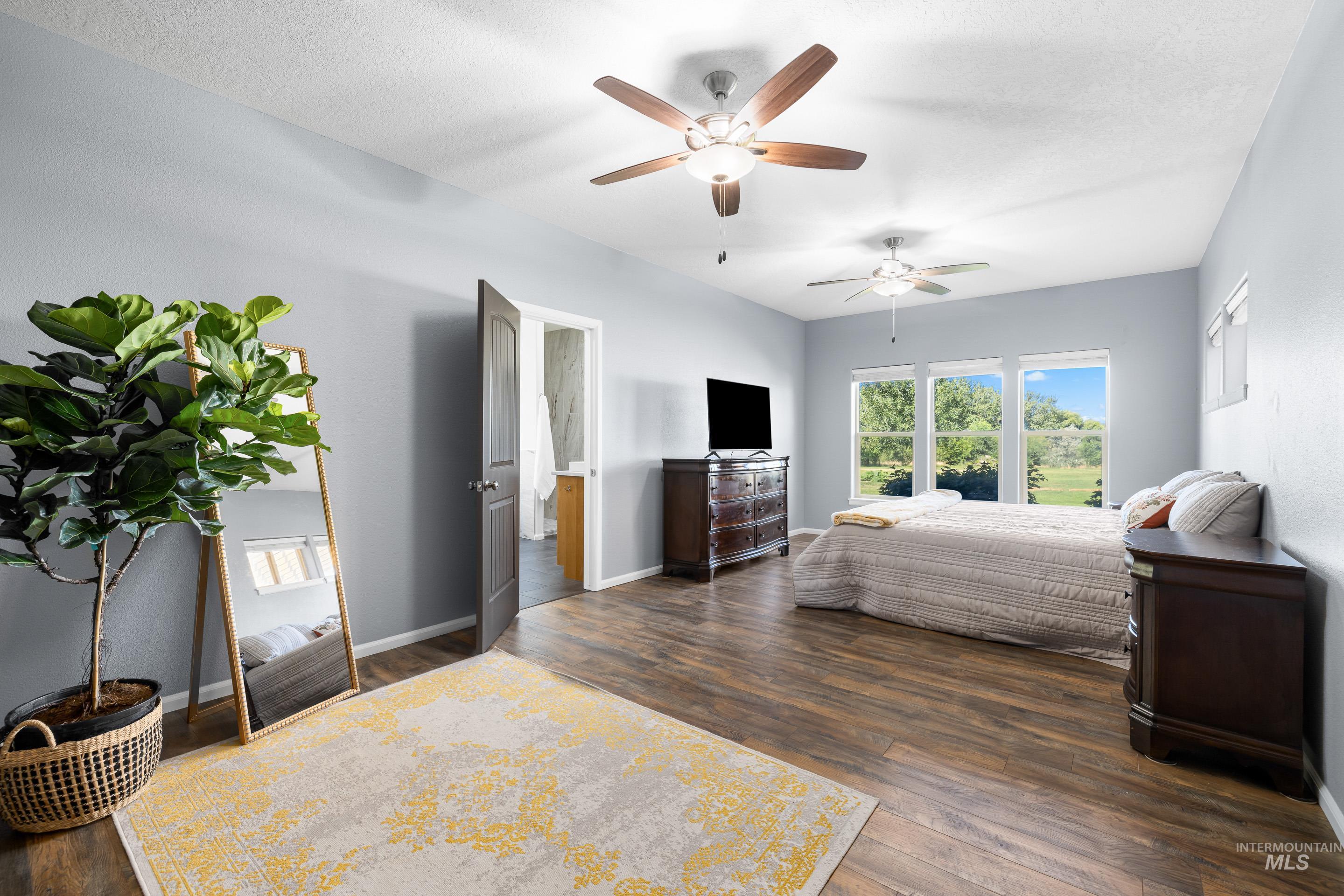 14119 Silver Ridge Road Caldwell, ID 83607 - Photo 20 of 50 Bedroom featuring a ceiling fan, dark wood-type flooring, and a textured ceiling