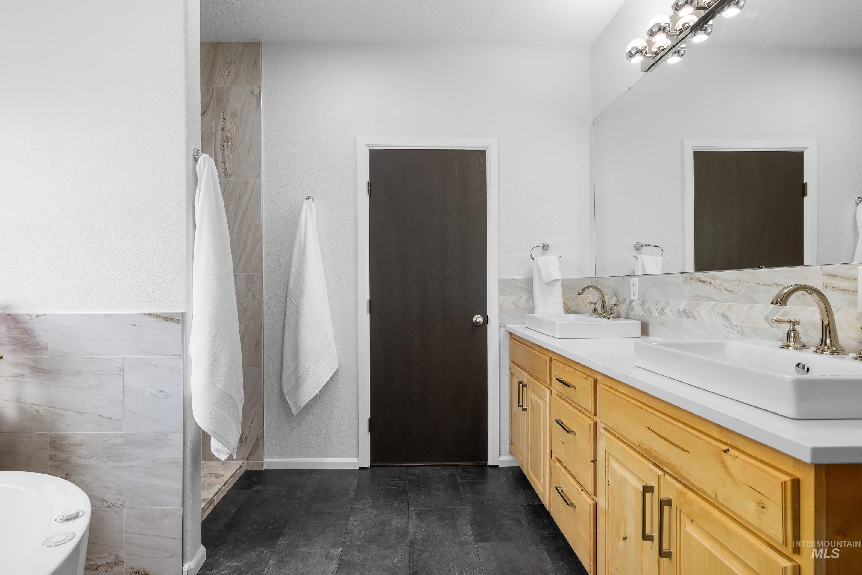 14119 Silver Ridge Road Caldwell, ID 83607 - Photo 22 of 50 Full bathroom featuring double vanity, a soaking tub, and tile walls