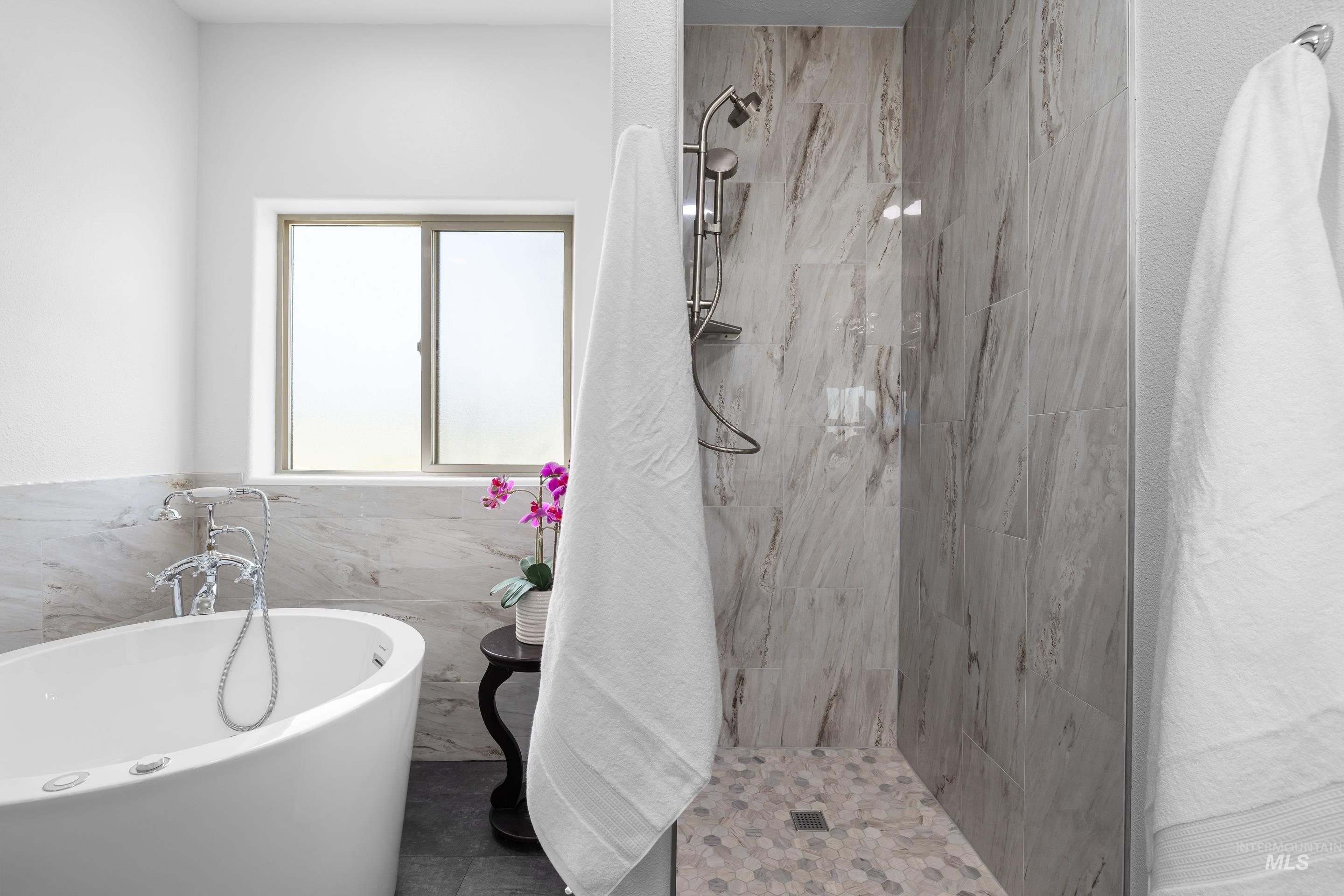 14119 Silver Ridge Road Caldwell, ID 83607 - Photo 24 of 50 Bathroom featuring a soaking tub, tiled shower, and tile walls