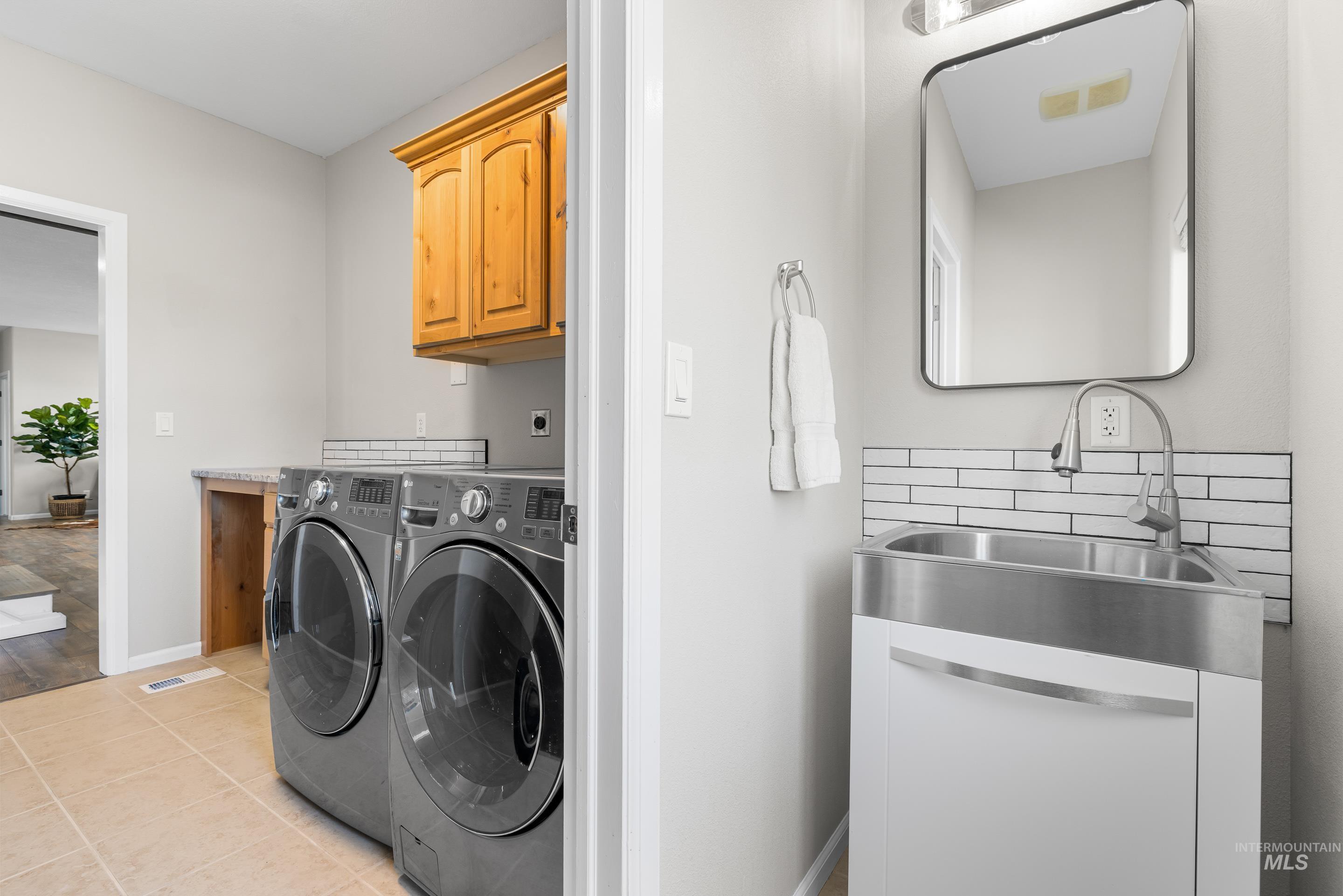 14119 Silver Ridge Road Caldwell, ID 83607 - Photo 44 of 50 Laundry room with light tile patterned floors, cabinet space, and washer and clothes dryer