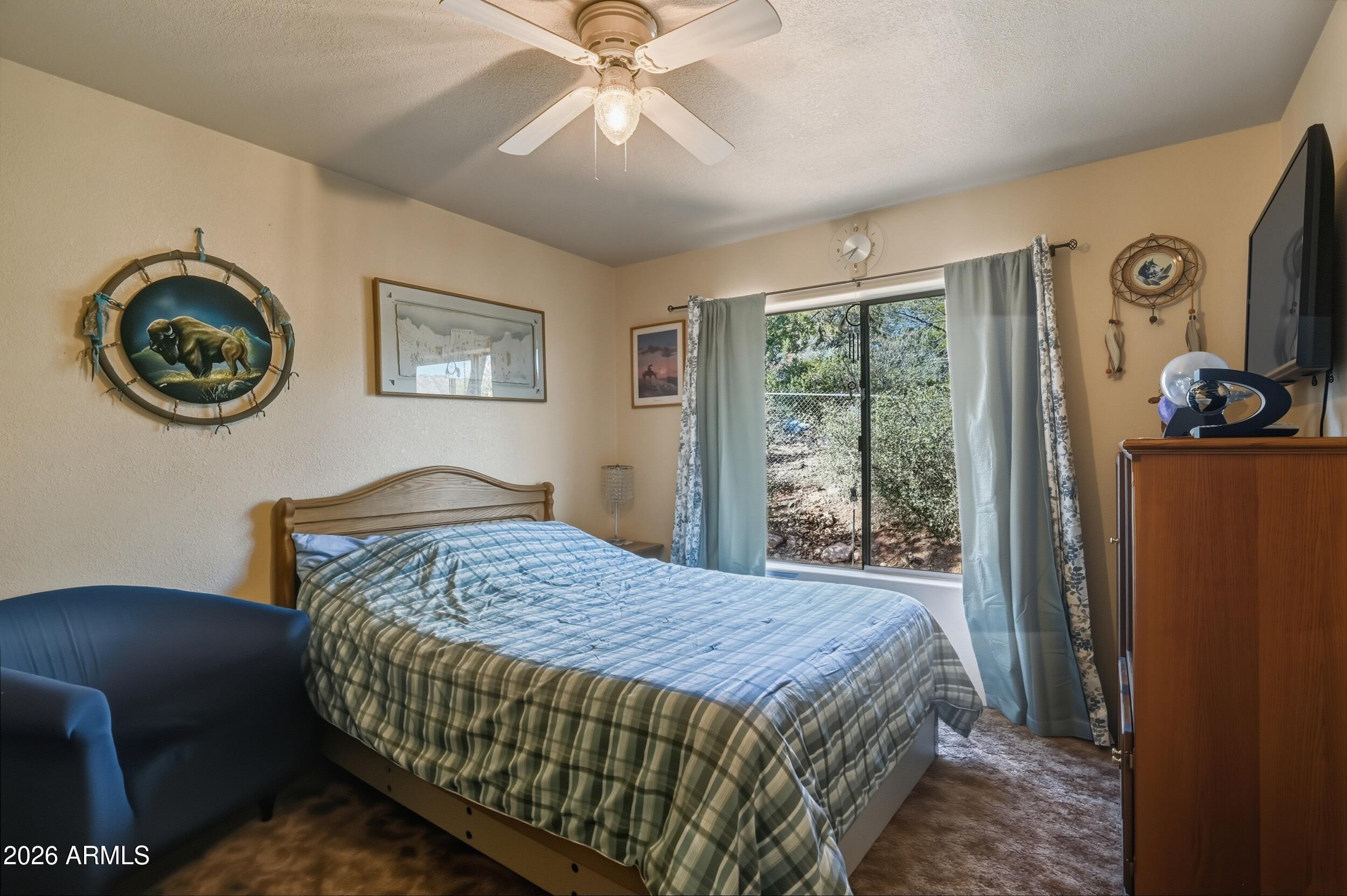 3119 Kysar Way Pine, AZ 85544 - Photo 27 of 68 a bedroom with a bed and a chandelier