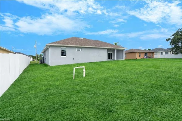 an aerial view of residential houses with outdoor space and trees