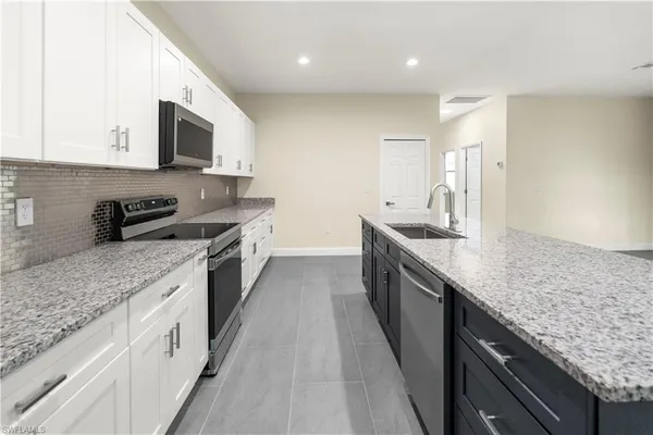 a large kitchen with stainless steel appliances granite countertop a lot of counter space
