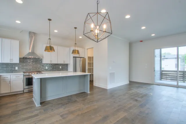 a large kitchen with granite countertop a stove and a sink