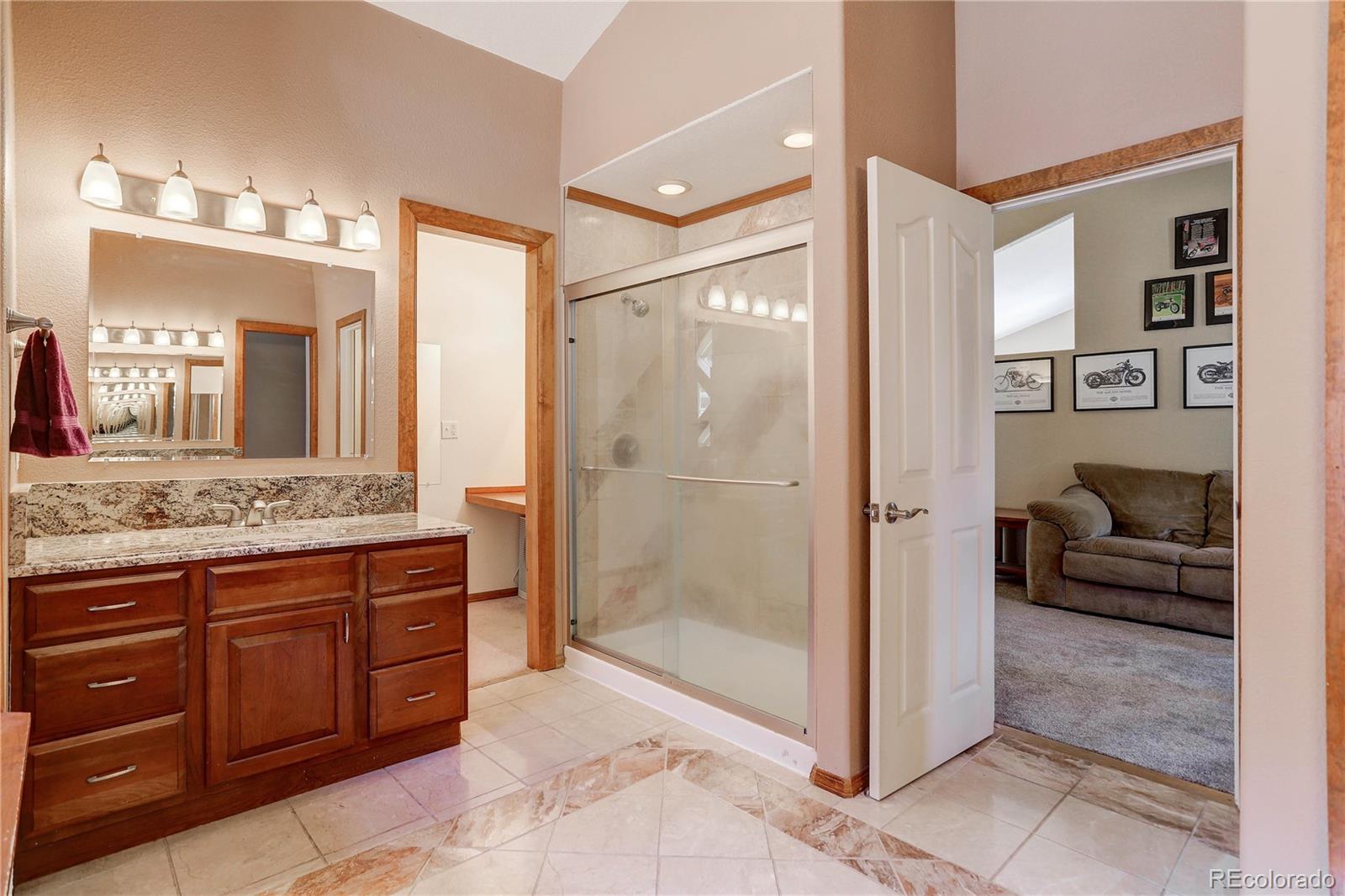 10922 Conifer Mountain Road Conifer, CO 80433 - Photo 26 of 37 a bathroom with a granite countertop sink mirror and shower