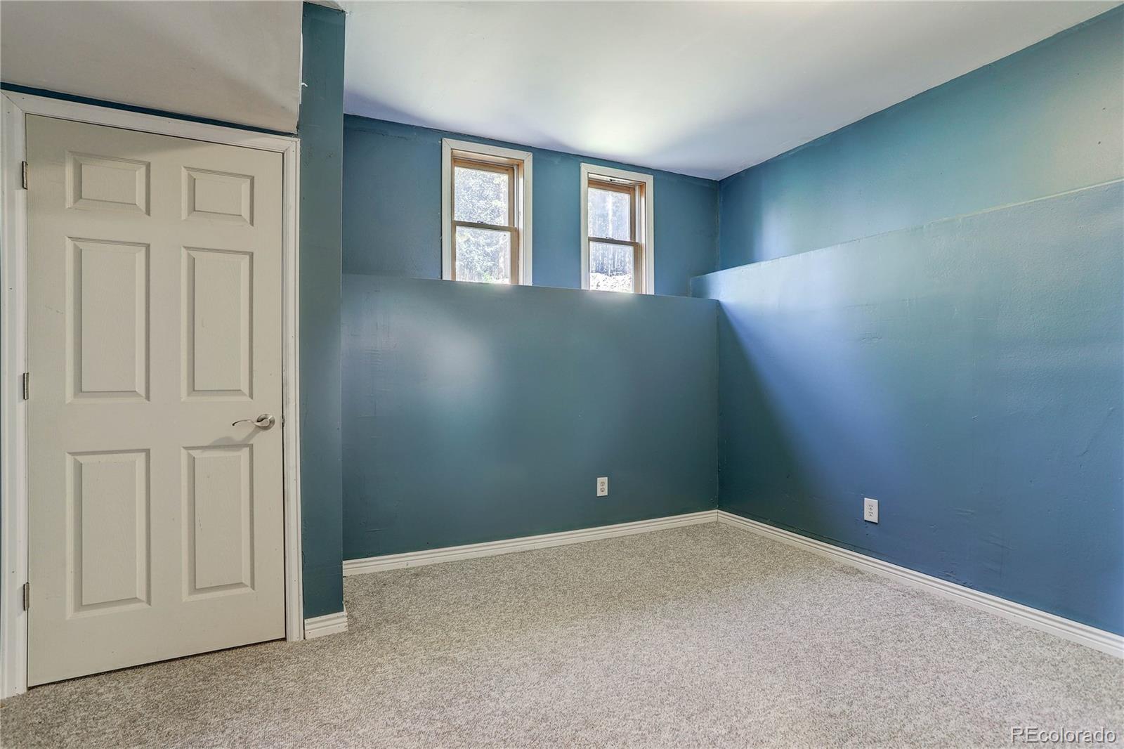 10922 Conifer Mountain Road Conifer, CO 80433 - Photo 31 of 37 an empty room with windows and closet