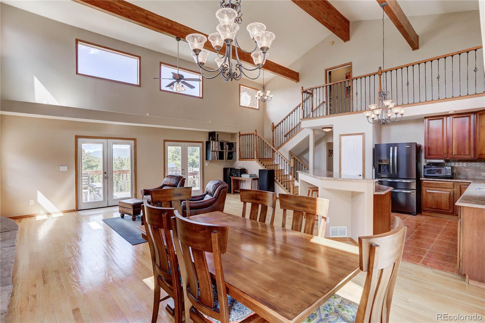 10922 Conifer Mountain Road Conifer, CO 80433 - Photo 7 of 37 a view of a dining room with furniture a chandelier and wooden floor