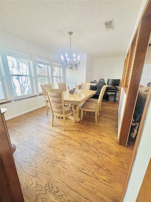 1109 Simpson Terrace Bedford, TX 76021 - Photo 19 of 39 a view of a dining room with furniture a chandelier and wooden floor