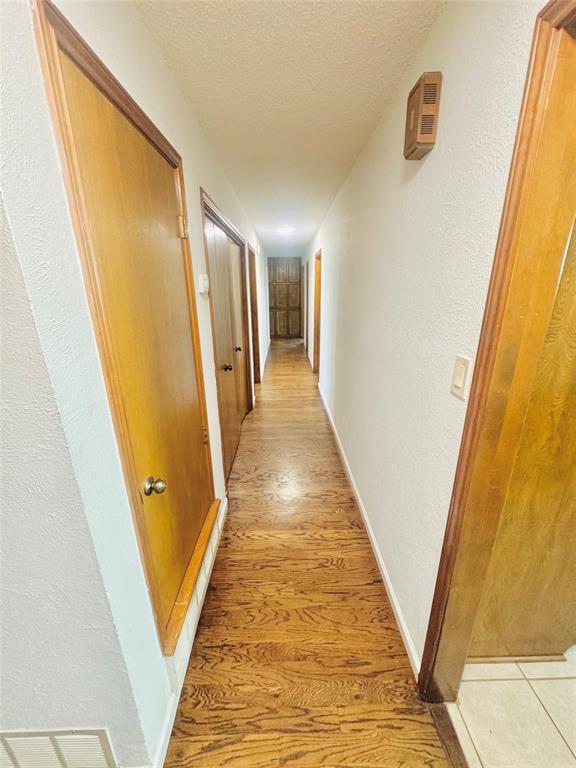 1109 Simpson Terrace Bedford, TX 76021 - Photo 22 of 39 a view of a hallway with wooden floor and staircase