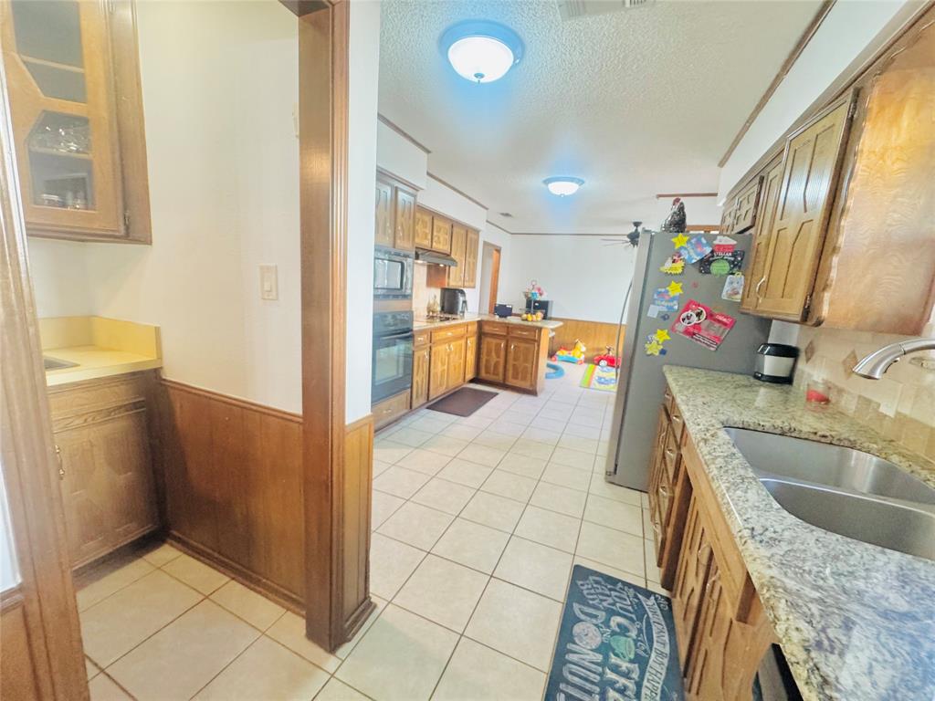 1109 Simpson Terrace Bedford, TX 76021 - Photo 23 of 39 a kitchen with a sink refrigerator and microwave