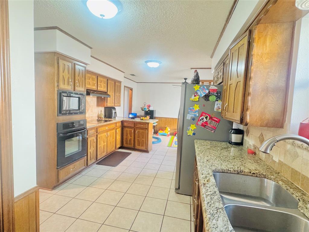 1109 Simpson Terrace Bedford, TX 76021 - Photo 24 of 39 a kitchen with granite countertop a sink a counter top space and cabinets